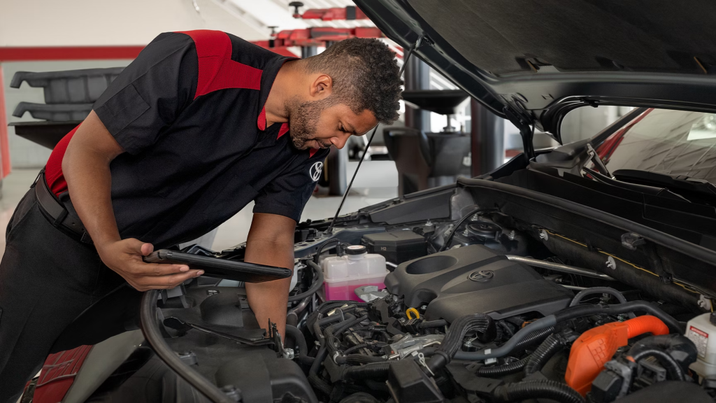 Mechanic servicing a car engine in a Toyota garage