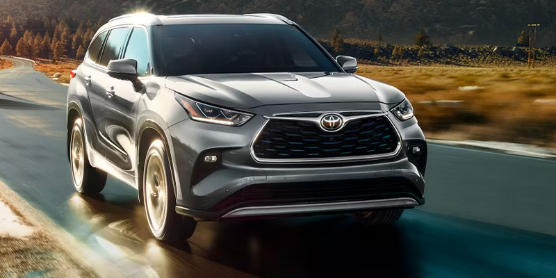A silver Toyota SUV driving on a scenic road.
