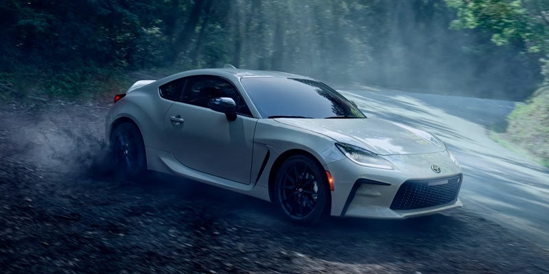 White sports car drifting on a forest road.